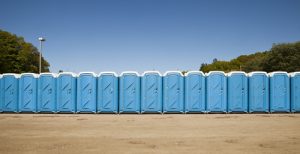 porta potties in an open dirt lot