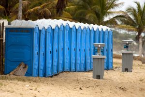 portable toilets on a beach with a hand washing station