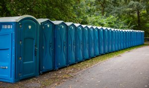 porta potties in a line next to a path